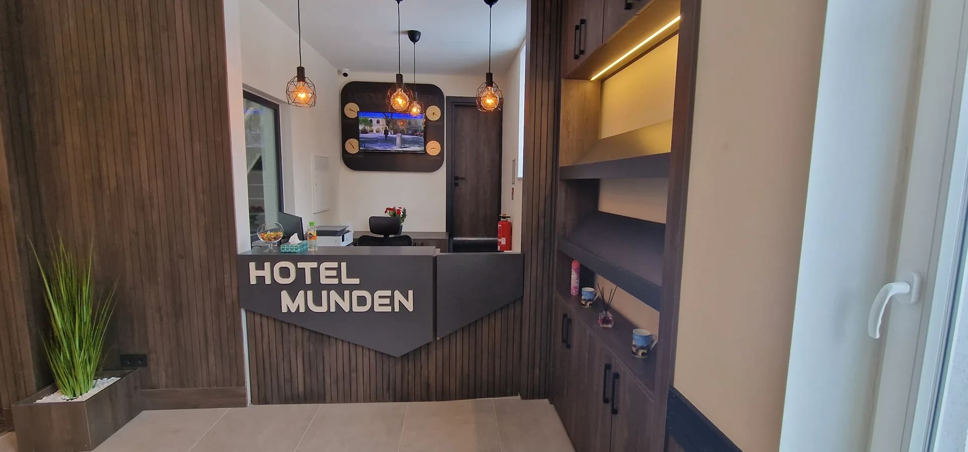 Rezeption des Hotel Münden mit dunkler Holzwand und Logo-Schriftzug