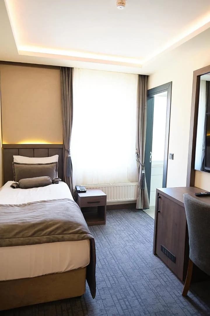 Einzelzimmer (306) mit Einzelbett und warmem Licht