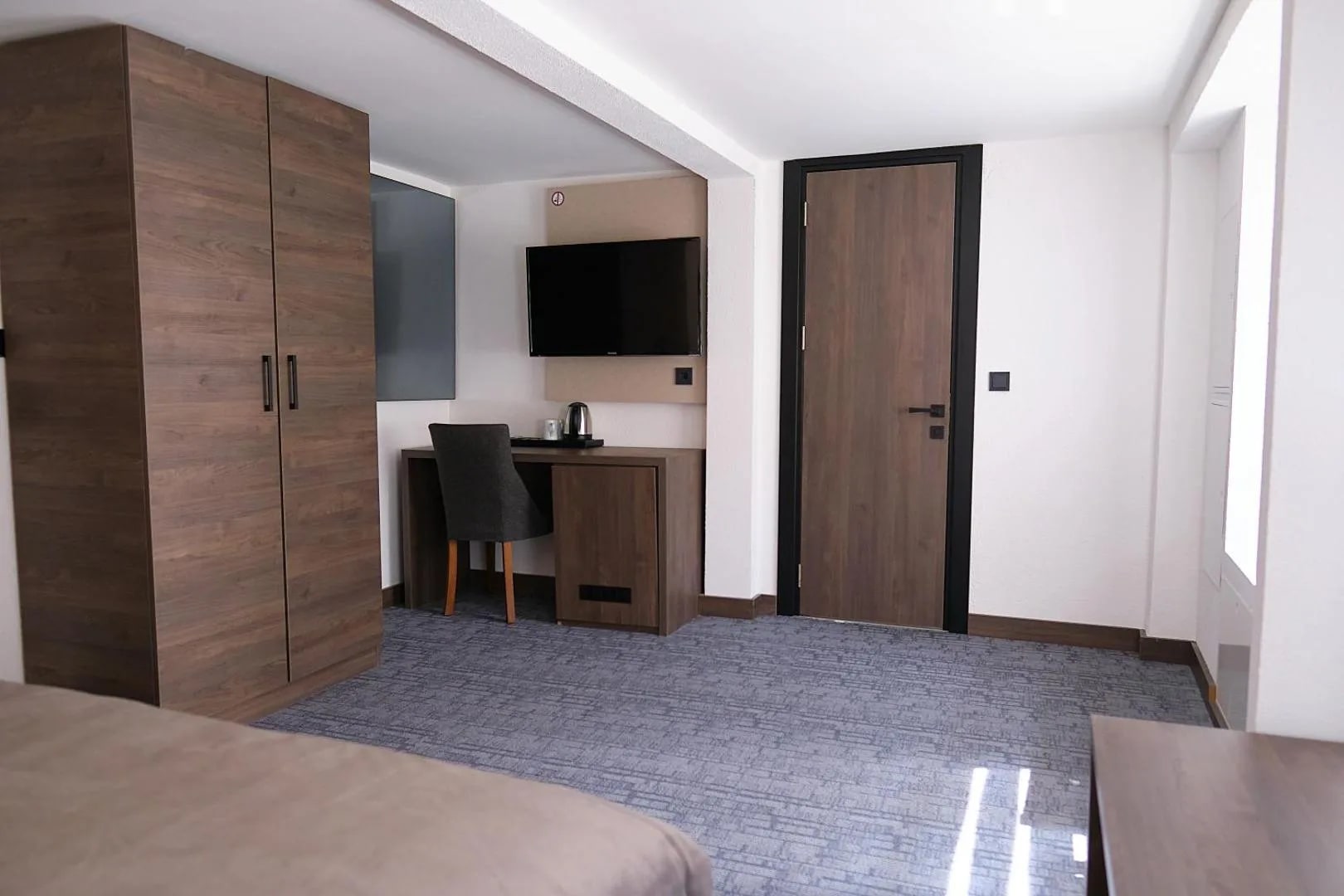 Kleines Doppelzimmer mit Schrank, Schreibtisch und Flat-TV